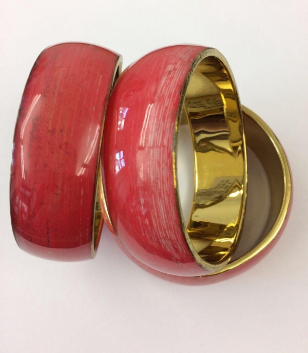 Red bangle of banana leaves on metal in acrylic | Goldschmiede Buhlheller